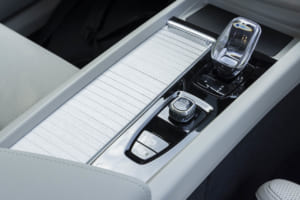ボルボXC60：エレガントなセンターコンソールのシャッターは、デコラティブパネルと同素材（ウッドパネル）で作られており、その下には、新しい2＋1カップホルダーを備えている。改良されたワイヤレス・スマートフォンチャージは、トンネルエリアの前方に移動され、使い勝手が大幅に向上。