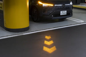 トヨタ・カローラ クロス：トヨタ車で初採用となる（日本初）シグナルロードプロジェクションSRPを採用。ウインカーと連動して光の矢印が点灯し、歩行者や周辺の車両への認識性を向上。これにより、夜間の見通しの悪い交差点などで発生しやすい出会い頭の衝突事故抑制に貢献する。