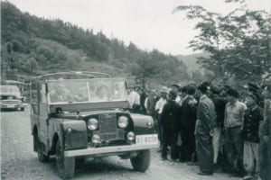 白洲次郎は1951年に東北電力の初代会長に就任し、只見川流域のダム開発を指揮した際にはランドローバー・シリーズ1を英国から取り寄せて、現地視察の足として愛用したという。写真は秩父宮妃殿下を乗せ運転する白洲次郎。写真提供：旧白洲邸武相荘。