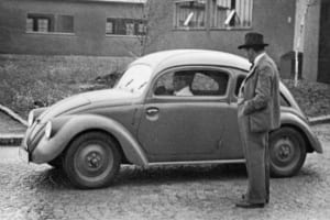 1937年に製造された30台の試作用フォルクスワーゲンの1台とその脇に立つポルシェ博士。