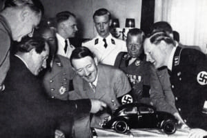 ポルシェ博士はフォルクスワーゲン・プラモデルを1938年ヒトラーの誕生日にプレゼントし熱心に説明（ナチス幹部室内）。