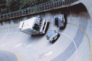 シュツットガルト・ウンタートゥルクハイム本社の90度バンクを激走するW201とW126。背後に迫るのは大型バスO303シリーズだ。