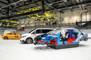 各モデルの安全構造の特徴を説明する車両群。手前の写真はEQS(BEV)のインテグラルセーフティコンポーネントボディシェル:各種材料はさまざまな色で示され、押し出しアルミニウムプロファイルのドアシル構造など、車両の衝撃吸収分散ゾーンを形成。車内は、シートベルトやエアバッグなどの各拘束システムが分かる。運転支援システムや受動的安全性システム作動に関する情報を提供するセンサーは黄色で明示。