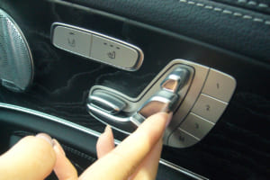 最近モデルでは、特にカドが無くなめらかで安全、しかも「指の腹」で押すようになっている。これは、マニキュアやネイルケアをした女性の指や爪を傷つけないための優しい気配り設計。しかも、3名分のシートポジションをメモリーできる。写真はEクラス／W213。