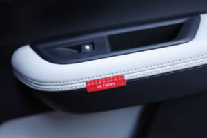 シトロエンC3 マックス ハイブリッド：アームレストの小さな赤いハッピータグには「be happy」「feel good」「be cool」「have fun」の4つの言葉が配されており、クスッとさせられる。