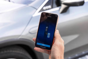 リモートパーキングアシストは、ドライバーが車外にいる間もスマートフォンを使って近くから車両を駐車・駐車解除できる機能。これにより、出入り時の快適性が向上し、ドアを開ける際の損傷から保護。写真はスマートフォンのアップ。