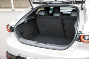 マツダ3 ファストバック XDドライブエディション：ルーフからリアゲートにかけてなだらかに傾斜したスタイルがマツダ3ファストバックの大きな特徴。そのためラゲッジスペースは多少犠牲になっているが、日常使いに問題はない。6：4分割の後席を倒せば大きな荷物も積載できる。