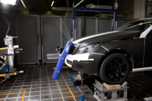 2009年5月発売のEクラス／W212には、「アクティブボンネット」を採用。歩行者と衝撃が発生すると、フロントバンパー内のセンサーが感知し、スプリング式のエンジンフードの後端が瞬時にして約5cm持ち上がる。従って、エンジンフードとエンジン間の空間が広がり、歩行者が受ける衝撃をさらに緩和。写真はボンネットに衝撃を加えたテスト。