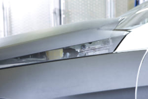 2009年5月発売のEクラス／W212には、「アクティブボンネット」を採用。歩行者と衝撃が発生すると、フロントバンパー内のセンサーが感知し、スプリング式のエンジンフードの後端が瞬時にして約5cm持ち上がる。従って、エンジンフードとエンジン間の空間が広がり、歩行者が受ける衝撃をさらに緩和。写真はボンネットが約5cm持ち上がった後部のアップ。