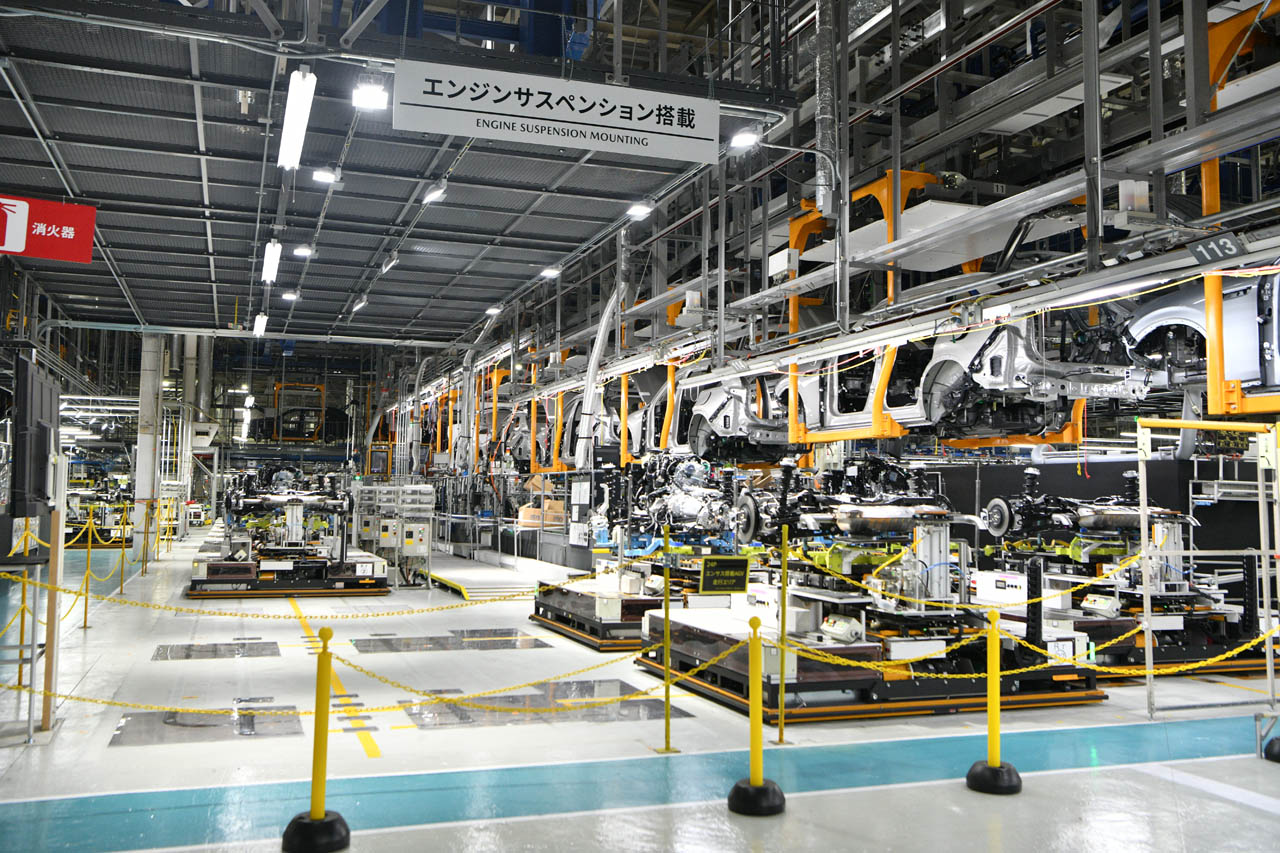 AGV（無人搬送機）を活用し、搭載位置が異なる車にもパワートレインを自動搭載。