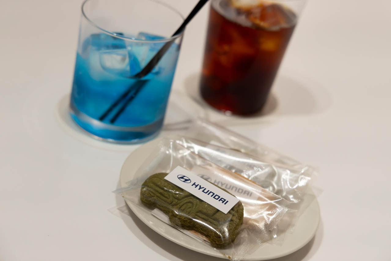点検作業や試乗に訪れた方には、ヒョンデのEVからインスピレーションを得たオリジナルコーヒー＆ティーをご提供。ブルーカラーが目を引く「N drink」は、サーキットを駆け抜ける疾走感をイメージしたノンアルコールカクテルも用意。